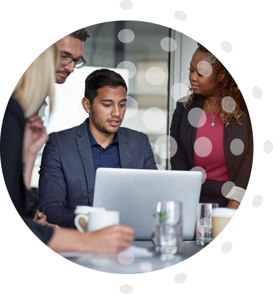 A group of diverse employees sitting around an apprentice's laptop in smart attire